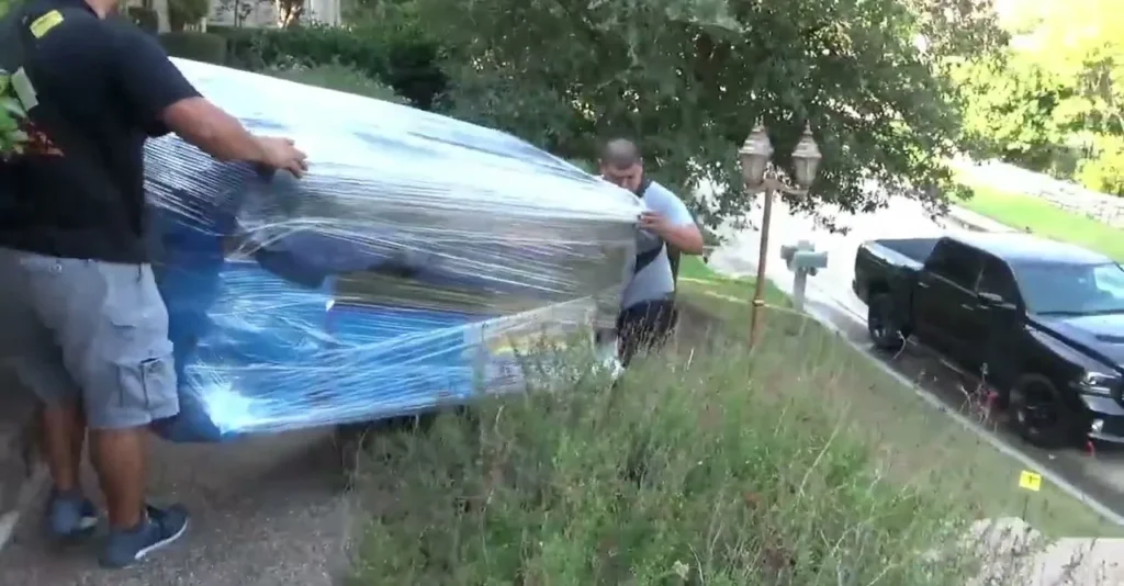 Paramount 14 Movers hand-carrying a wrapped couch down a driveway